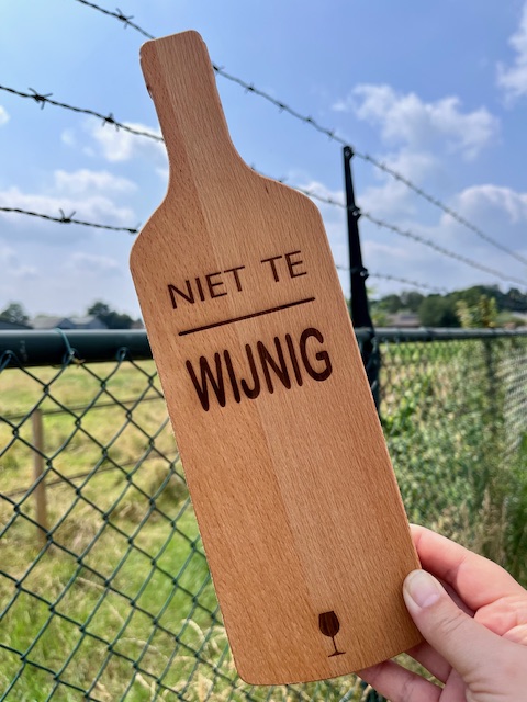 Borrelplank in de vorm van een wijnfles met daarop in lasergravure; niet te wijnig